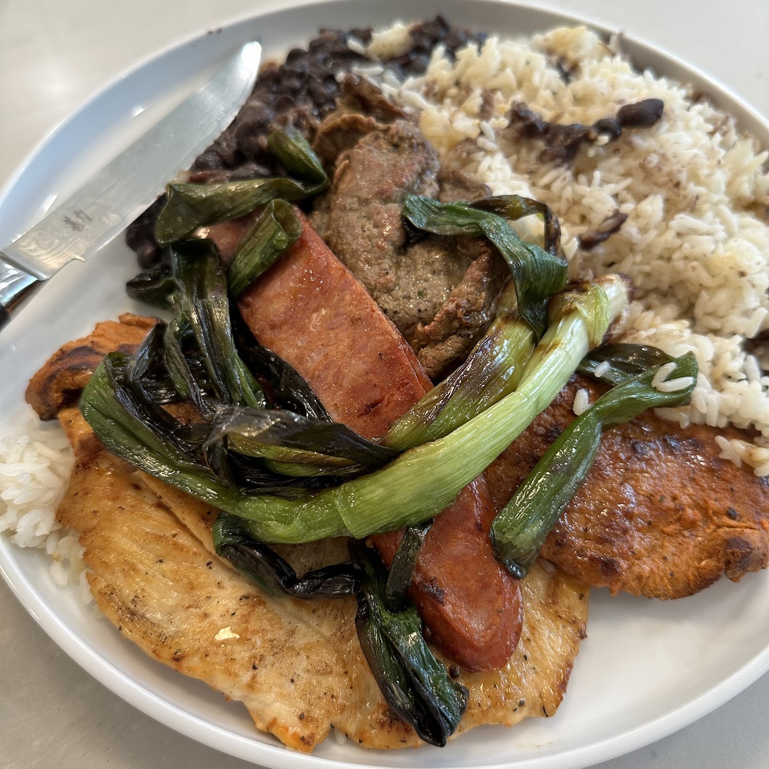 El Torito Deli Guatemala plate — grilled chicken, carne asada, chorizo, charred scallions with rice and black beans